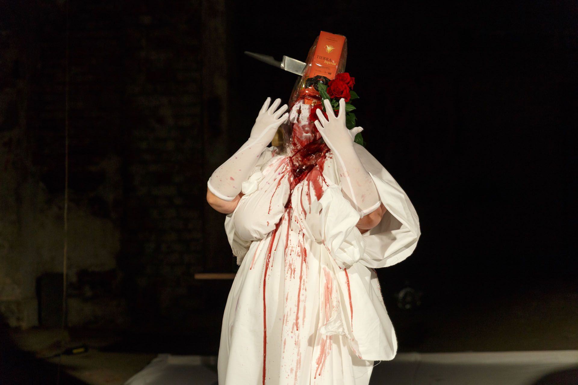 A person in white clothes and blood dripping down.