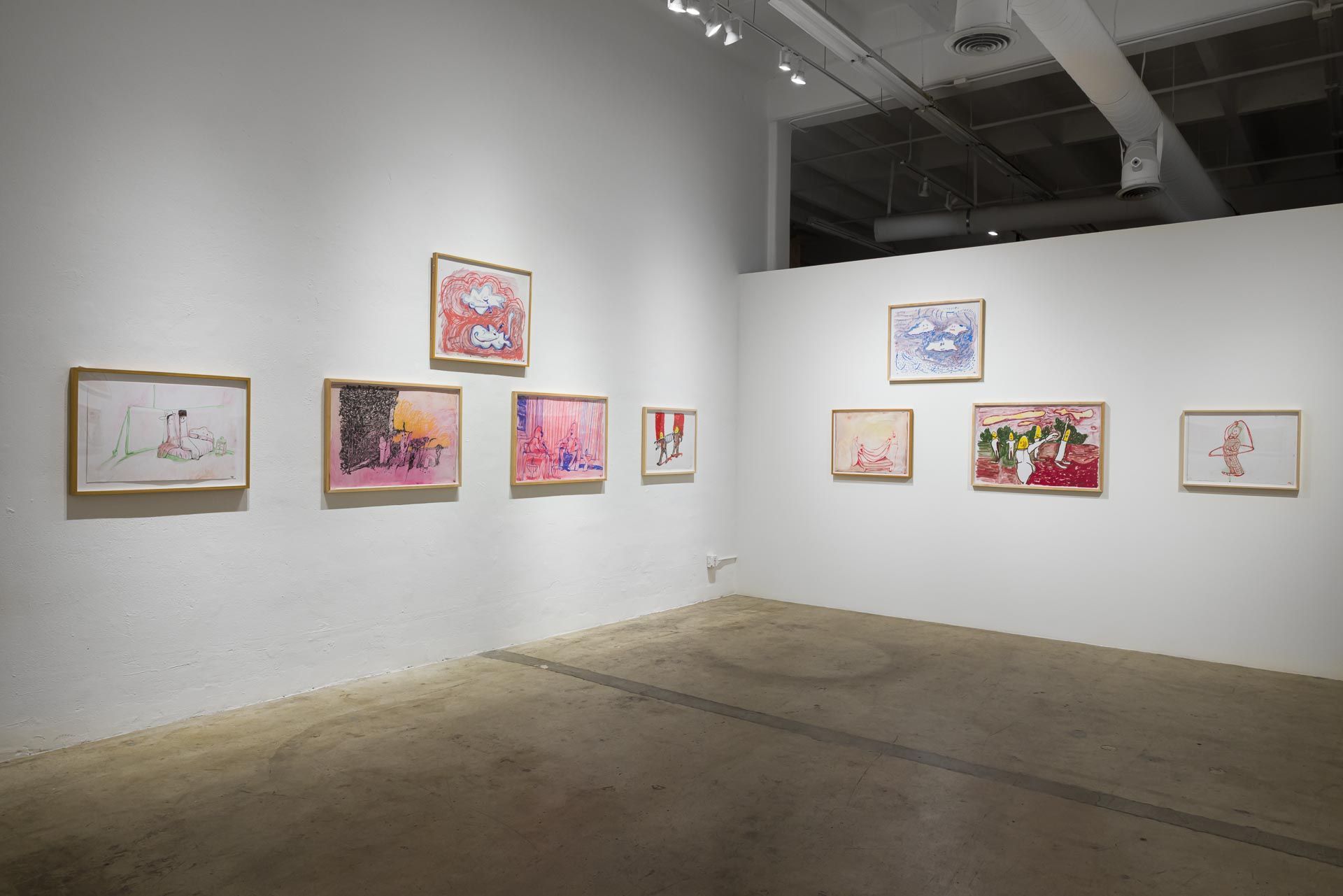 Wood-framed drawings on two white walls meeting in a corner, track lighting and dark ceiling beams above. Installation view, Kathleen Henderson: Clappers, Track 16.