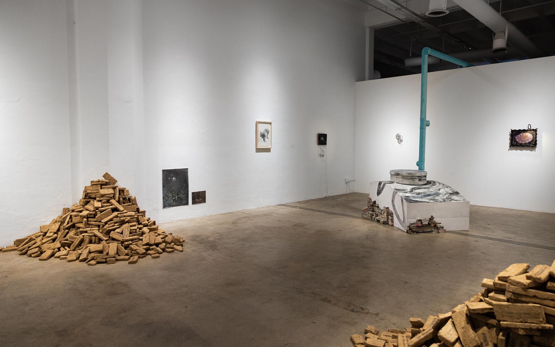 Art gallery with piles of wood chips, white walls, and abstract sculptural installations. Praise the Dying Beauty art exhibition at Track 16 Downtown Los Angeles gallery. Curated by Galia Linn featuring sculpture, paintings and drawings. 