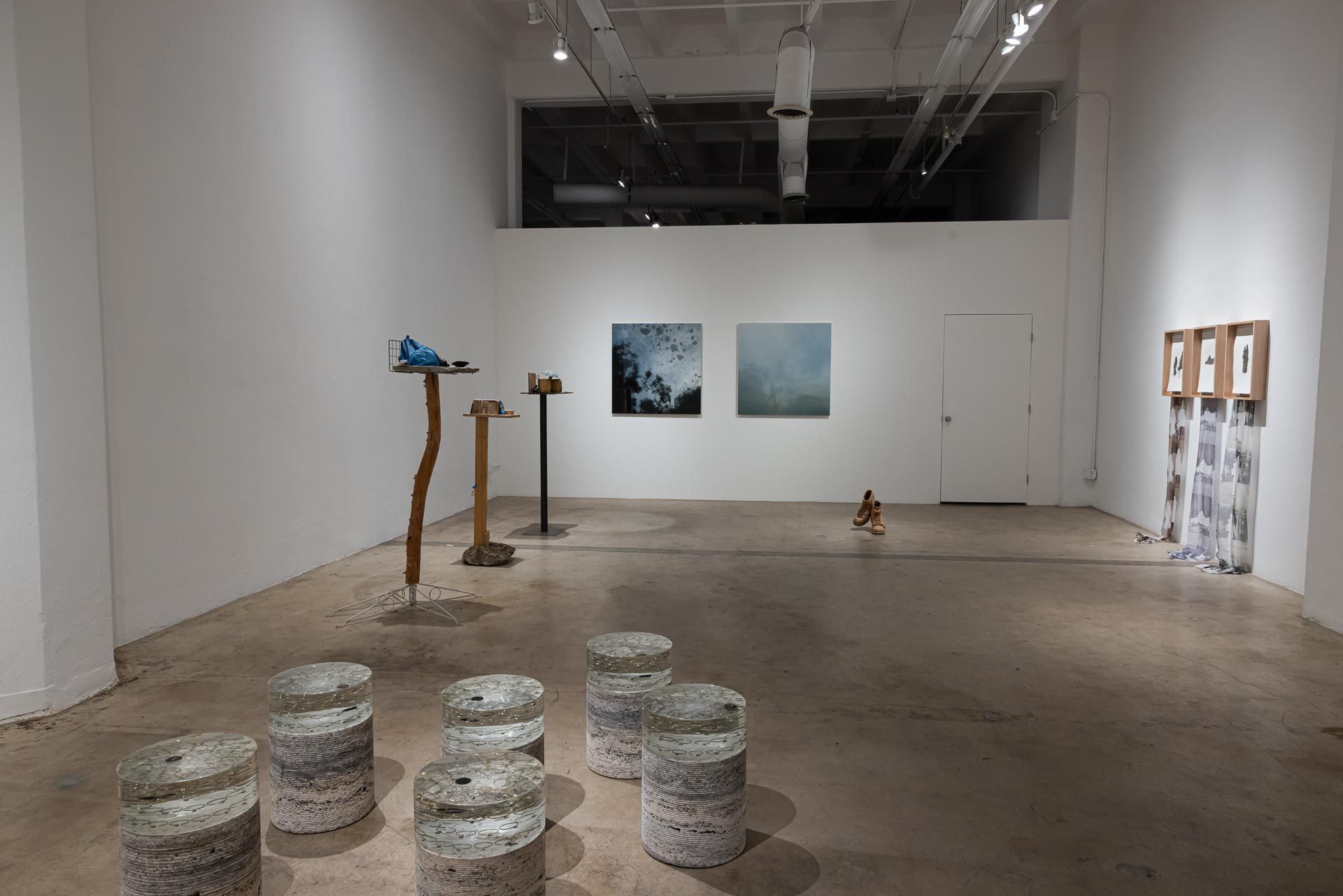 Minimalist art gallery with sculptures, hanging artworks, and white walls in a large open room. VALENCE group art exhibition at Track 16 Downtown Los Angeles featuring sculptures and paintings. Featured artists Azadeh Shladovsky and Daniel Wheeler, Curated by Galia Linn.