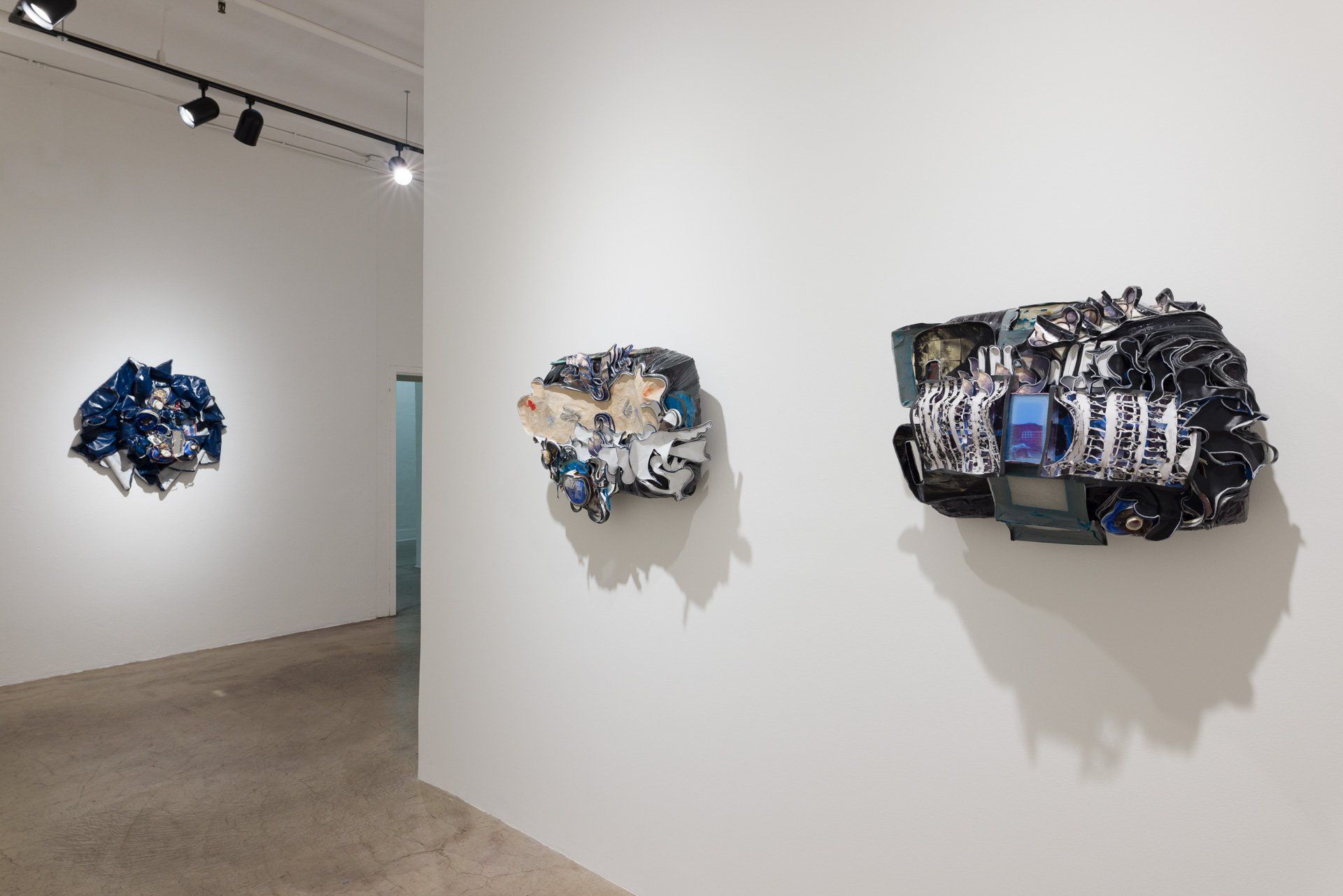 A room with three pieces of art on the wall.