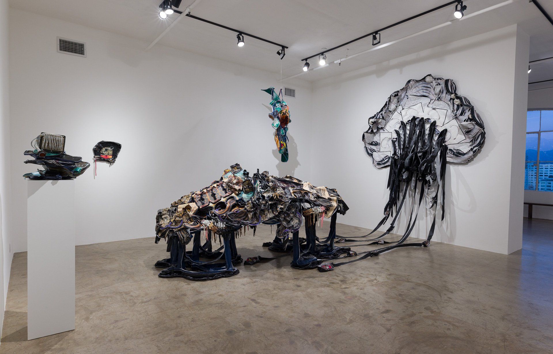 Sculptures hanging from the walls and on the floor of Track 16 Gallery.