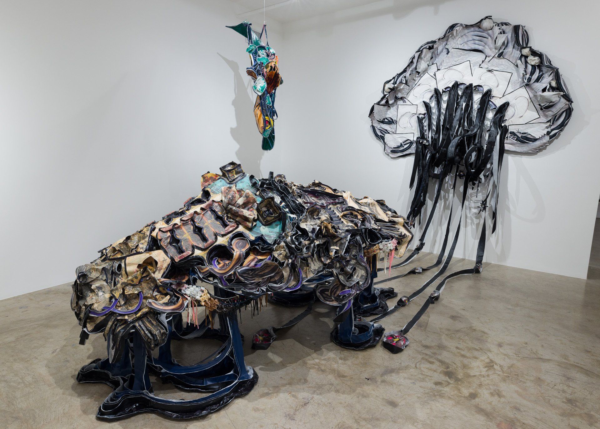 A large sculpture in a room with a painting on the wall behind it.