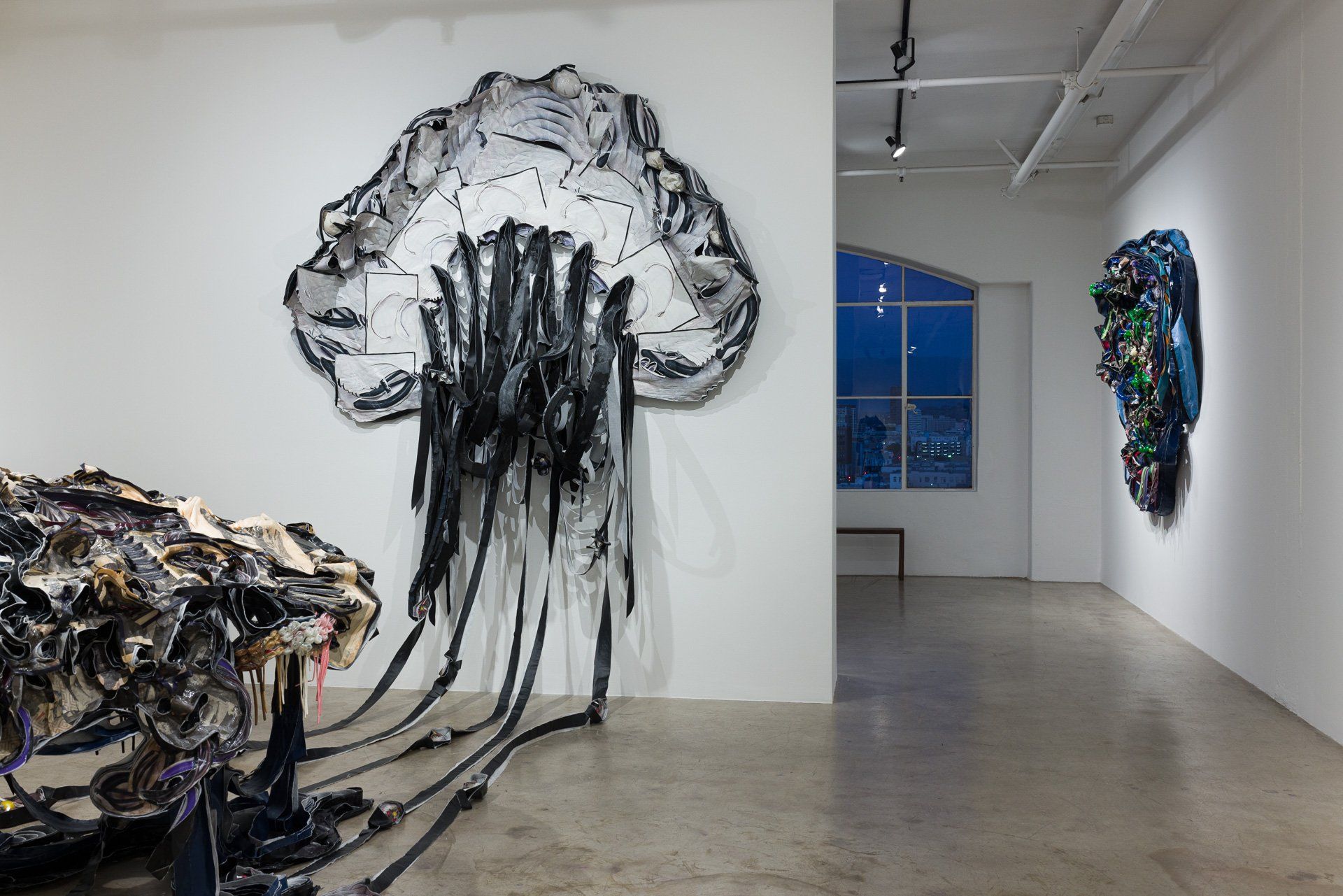 A large sculpture of a jellyfish is hanging on a wall in Track 16 Gallery.