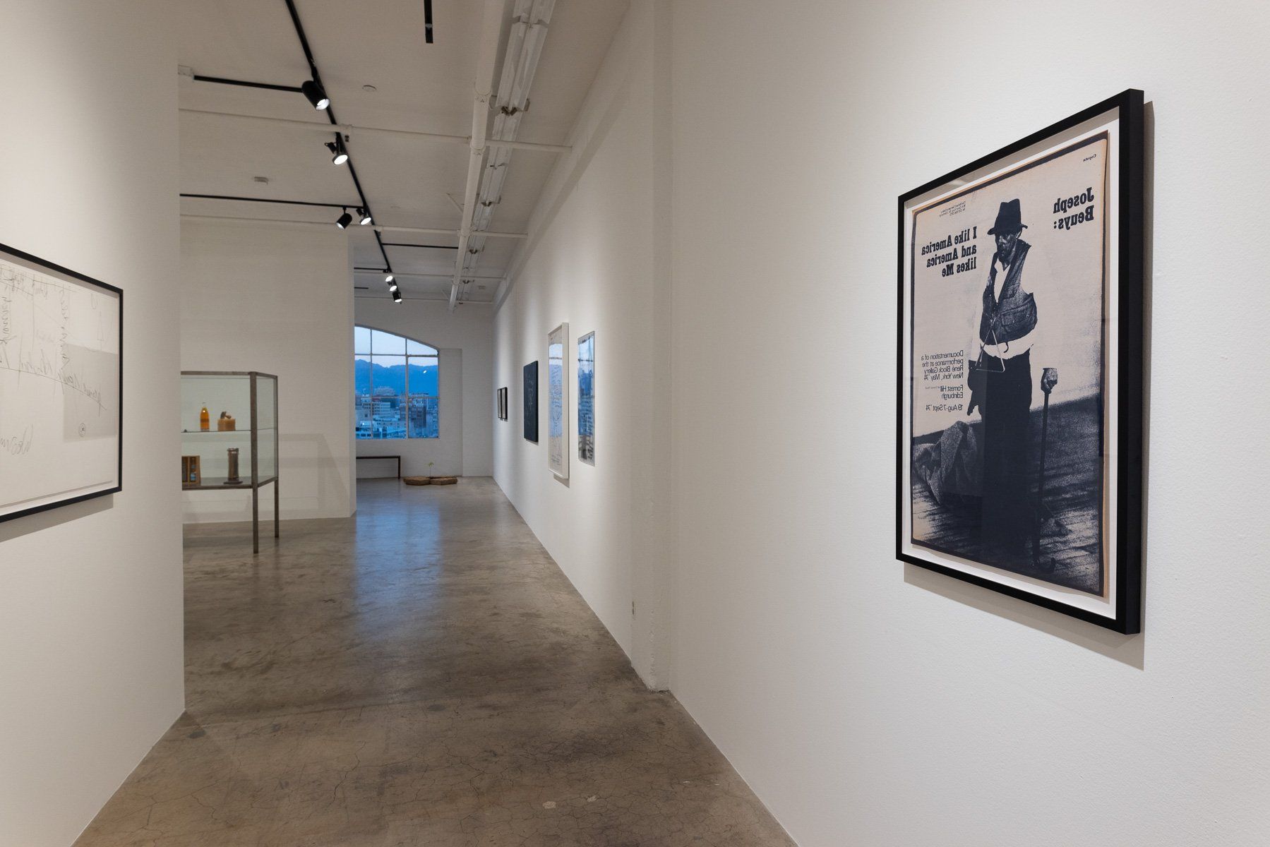 A long hallway with a picture of a man in a hat on the wall.