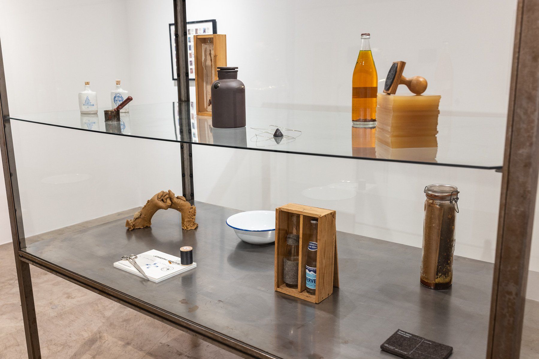 A table with a glass shelf and various objects on it.