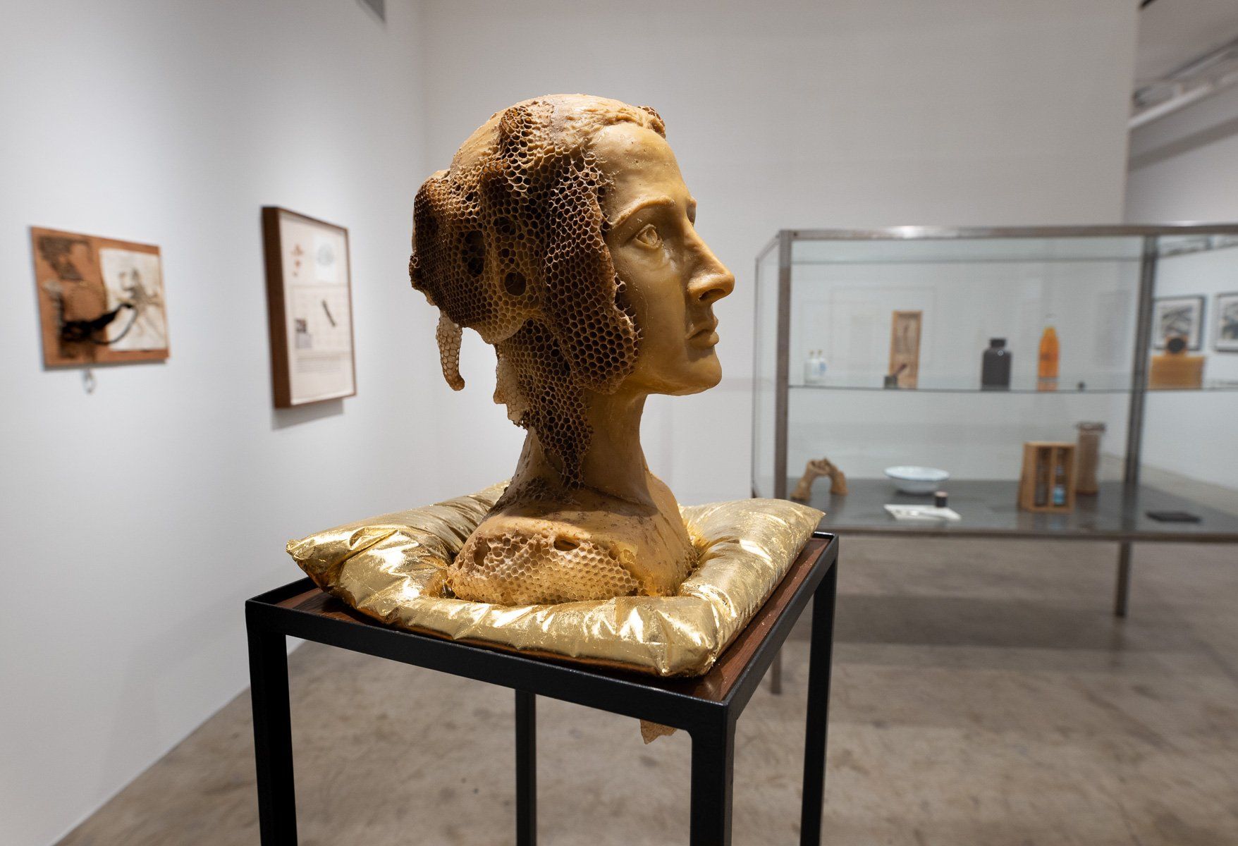 A statue of a woman 's head is sitting on a table in Track 16 Gallery.