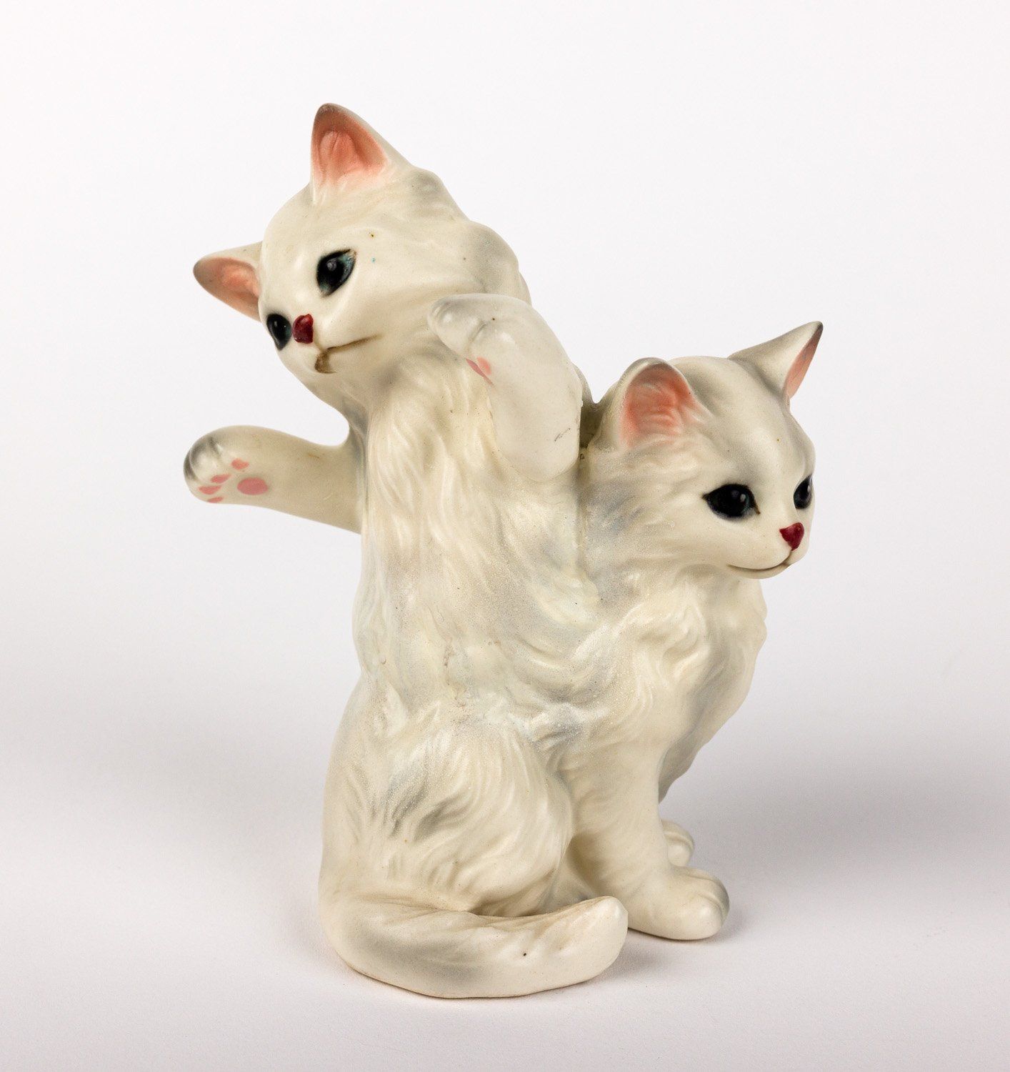 A statue of two white cats standing next to each other