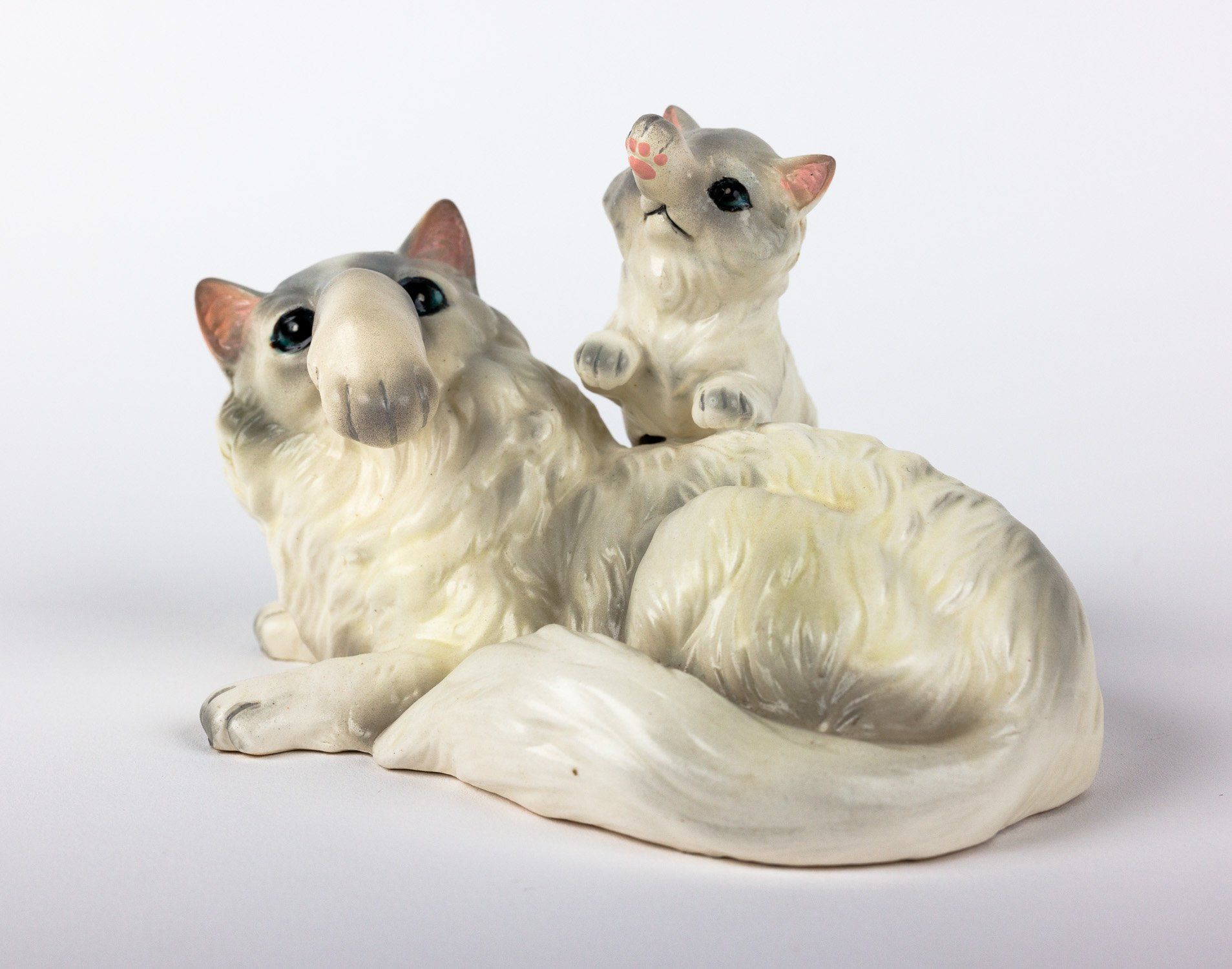 A statue of a cat and a kitten on a white background