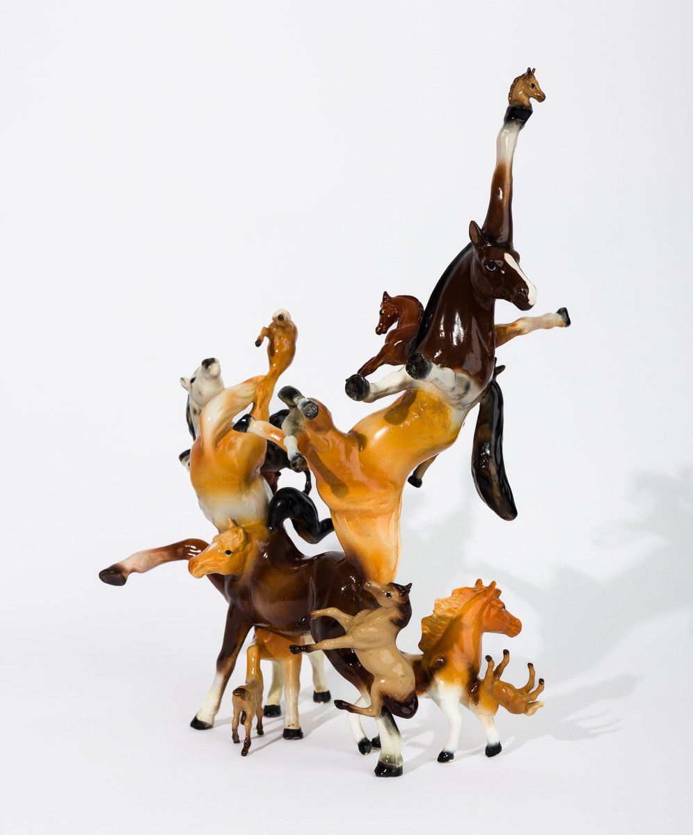 A group of toy horses are stacked on top of each other