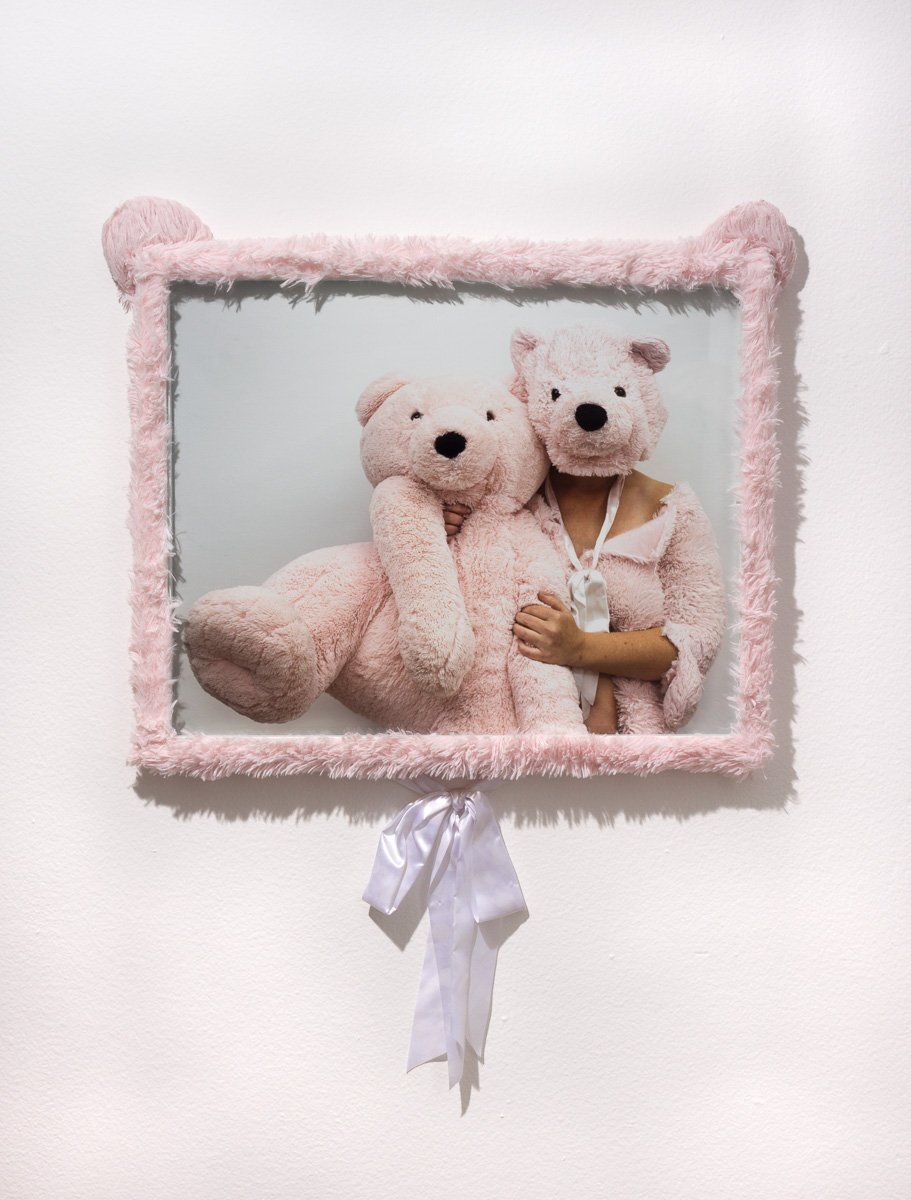 A picture of two pink teddy bears in a pink frame