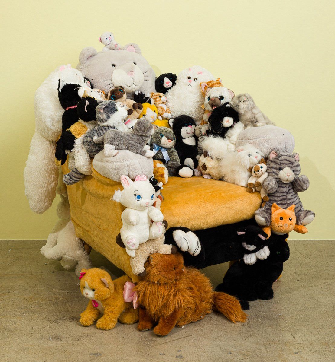 A bunch of stuffed animals are sitting on a chair