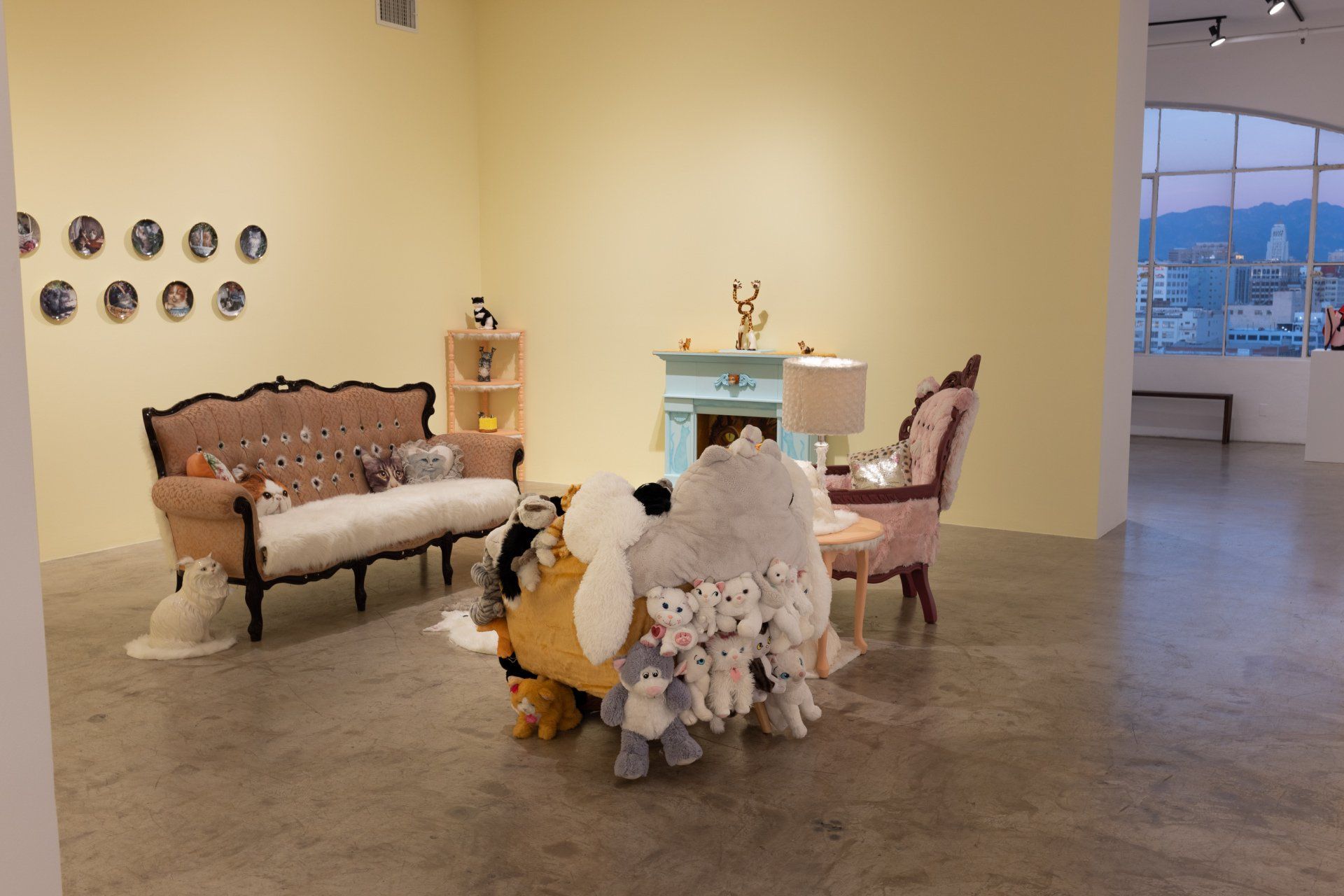 A living room with a couch , chairs , and a fireplace filled with stuffed animals.