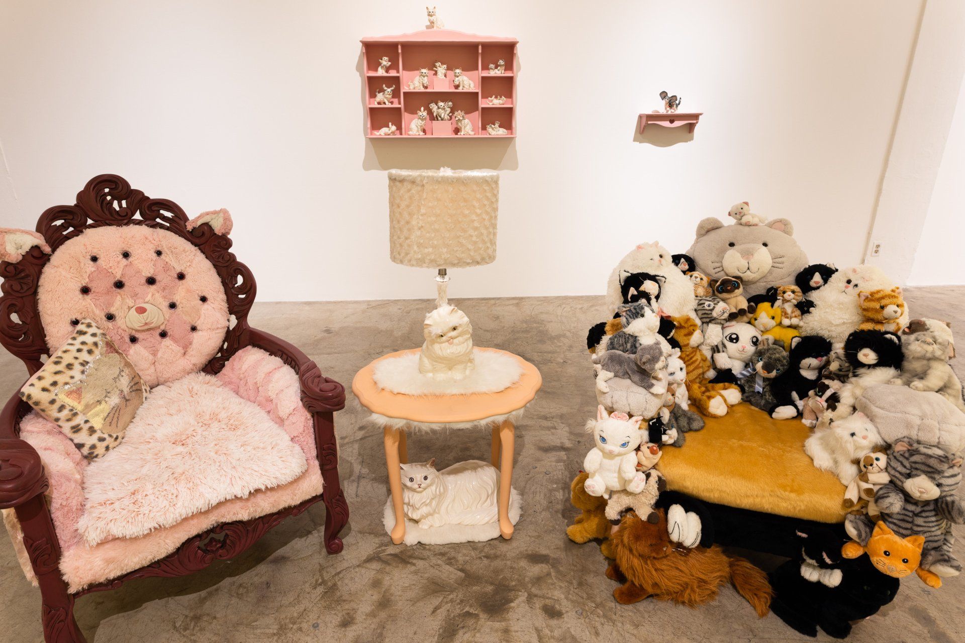 A room with two chairs and a table filled with stuffed animals.