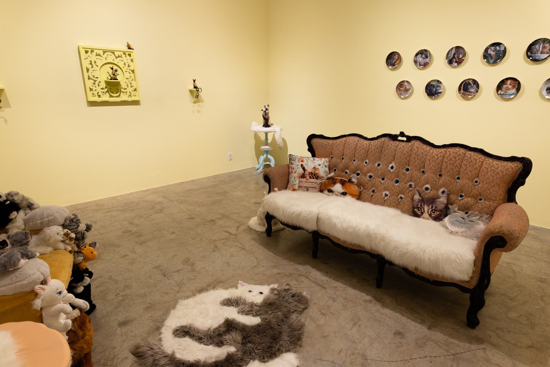 A living room with a couch and a rug with cats on it.