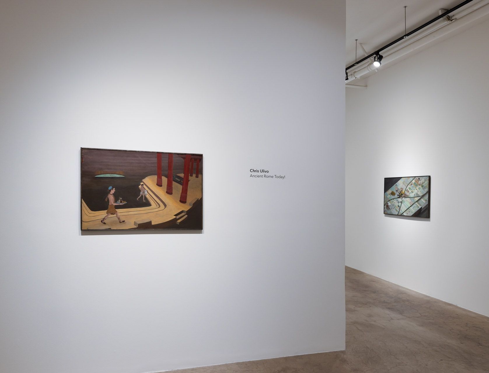 Two paintings are hanging on a white wall in a room.