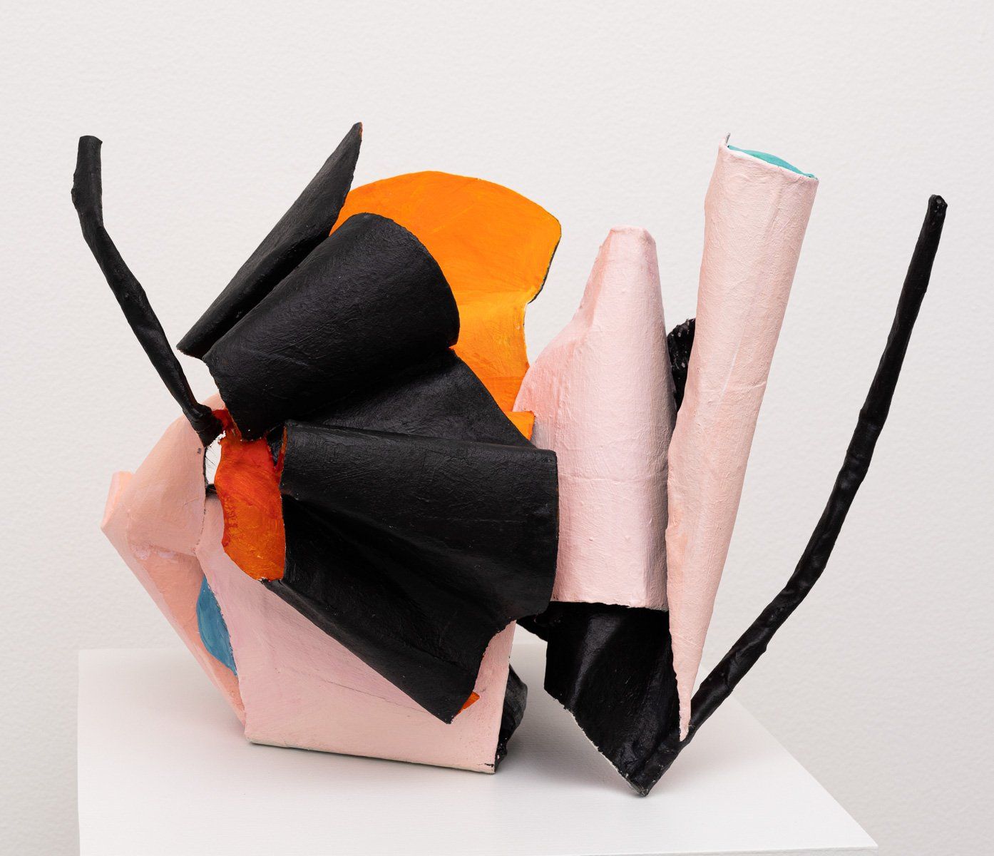 A colorful sculpture is sitting on a white pedestal