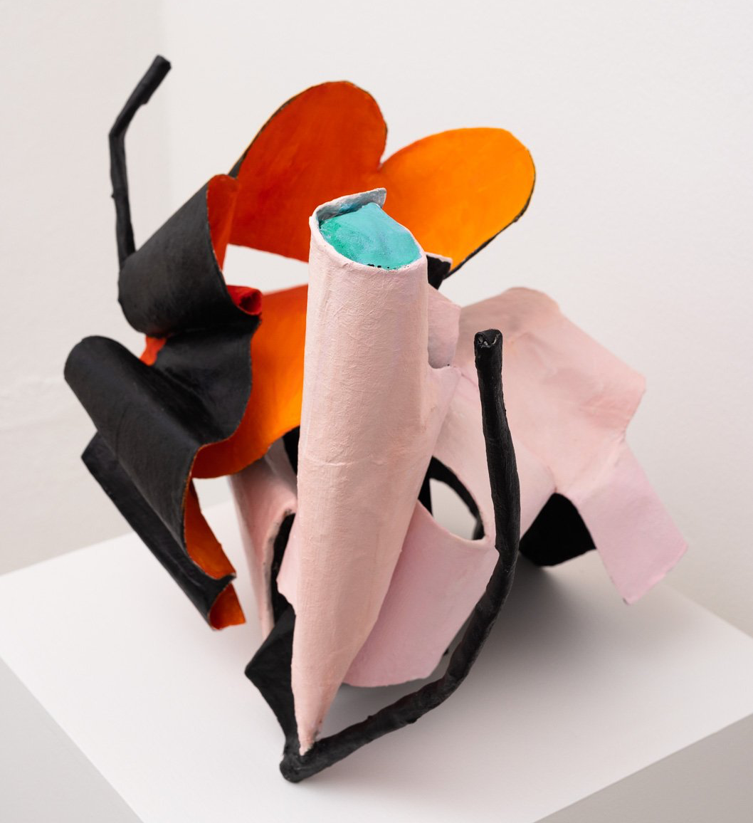 A colorful sculpture is sitting on a white shelf