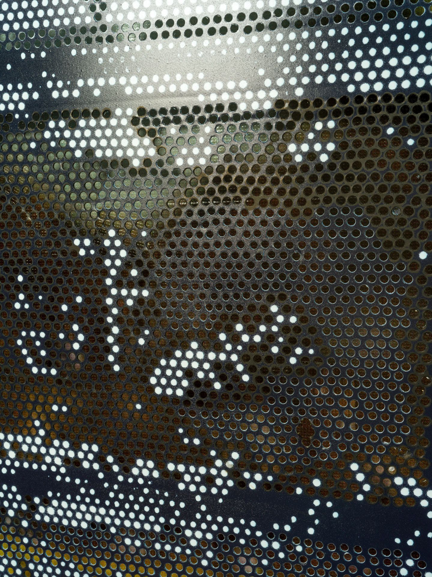 A close up of a metal surface with holes in it.