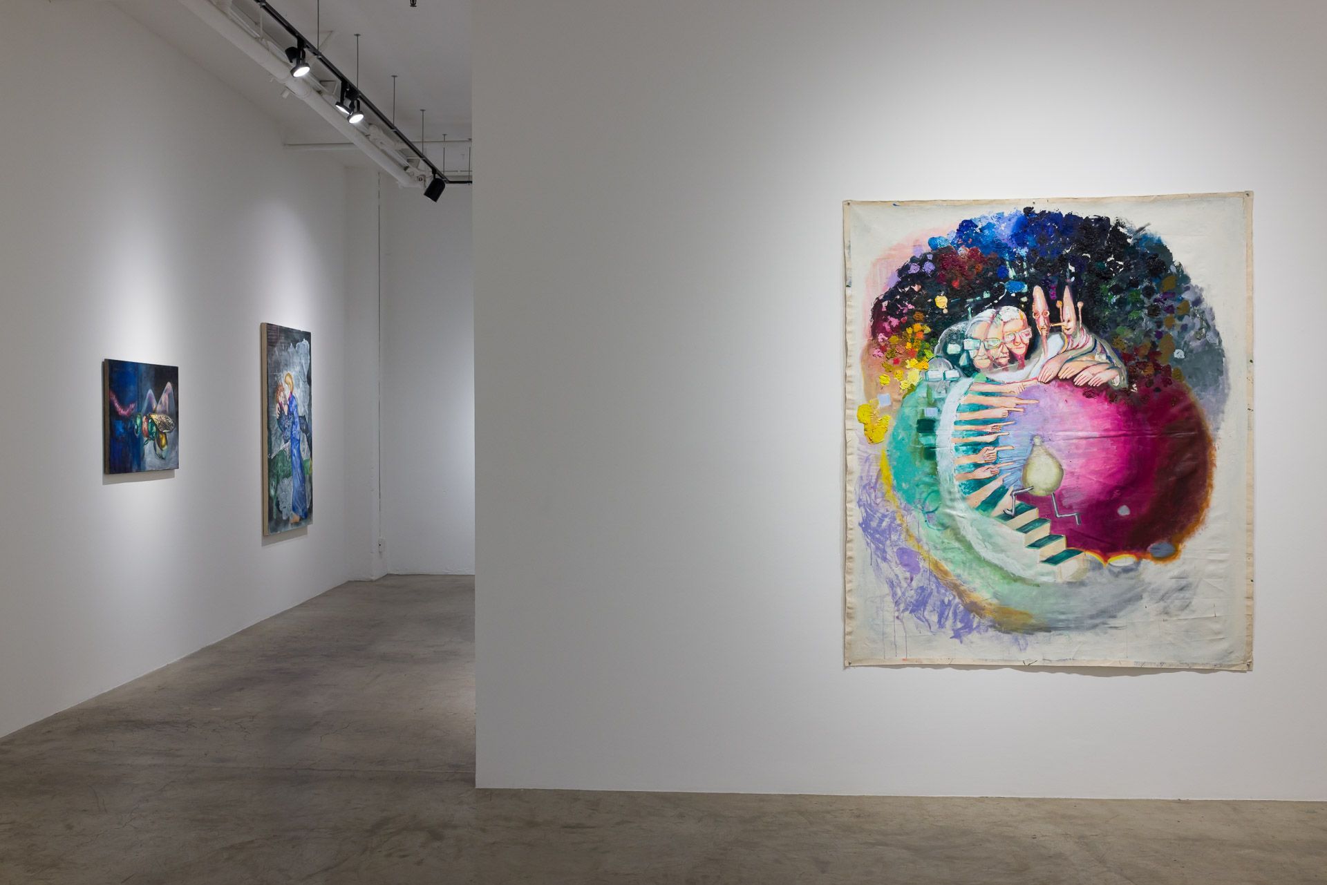 Art gallery hallway with colorful abstract paintings on white walls and a large vibrant circular artwork in the foreground