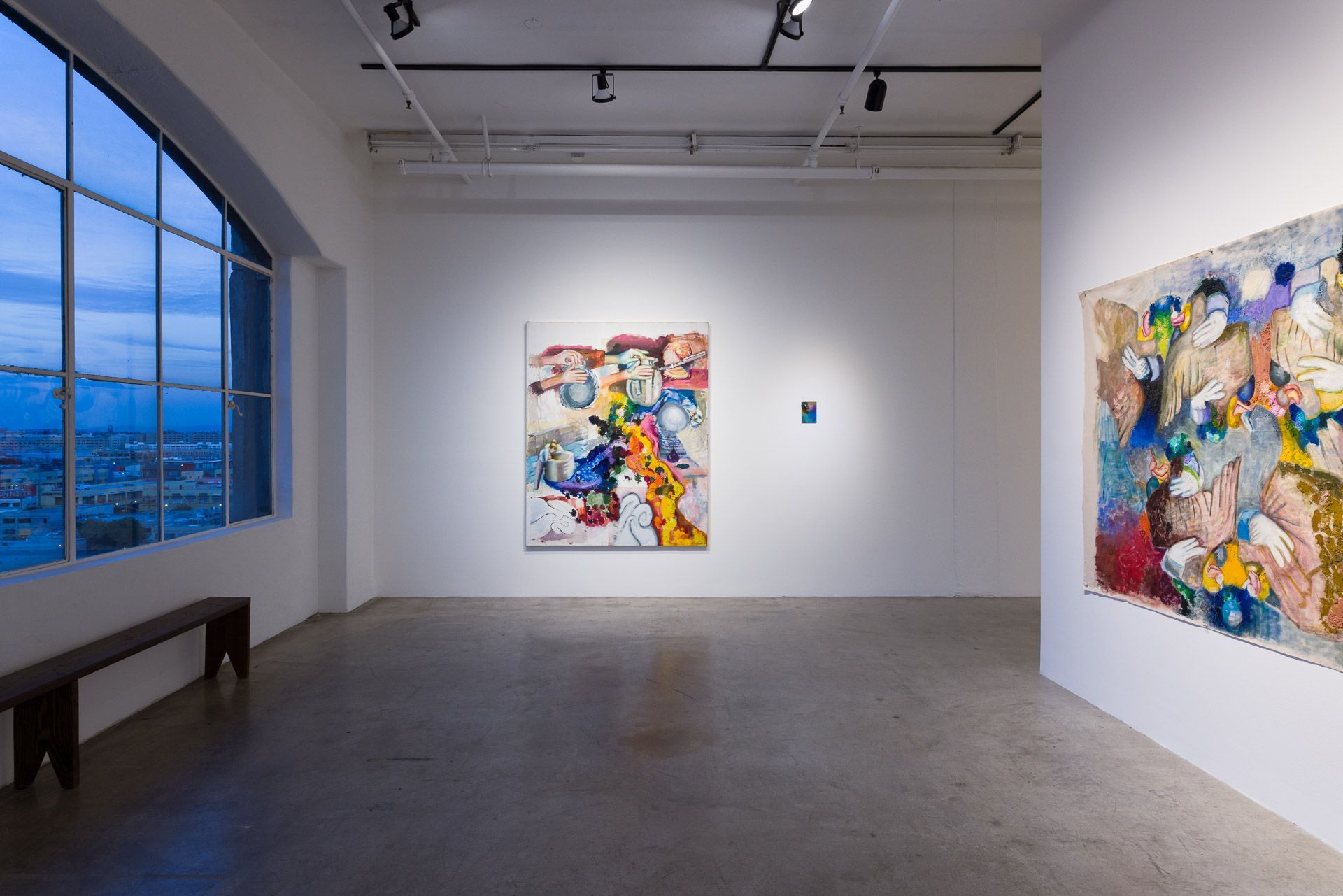 Large colorful tangled-form painting on the left wall and a very long multicolored painting of figures on the right wall. Installation view, Margarete Hahner: Heimlich, Track 16.