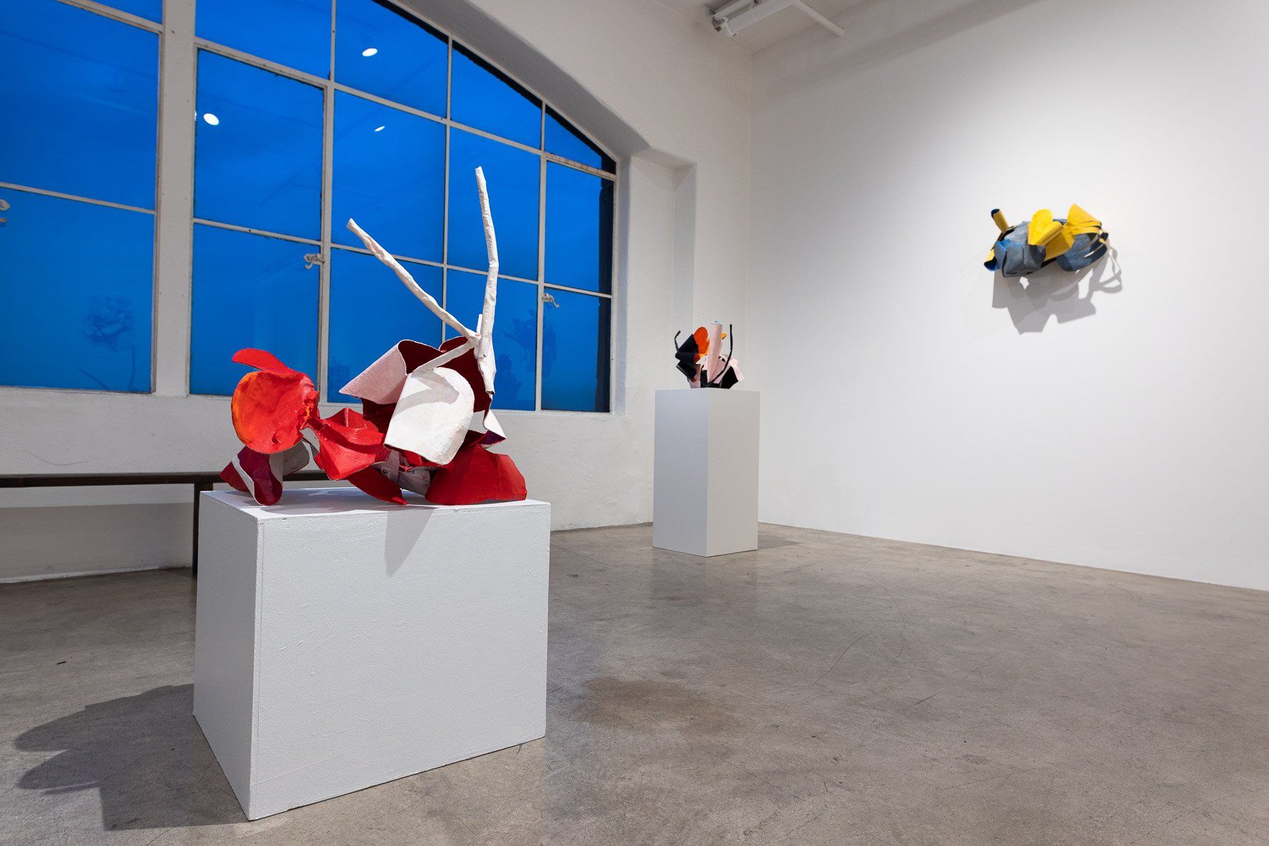 A room with a lot of windows and sculptures on display