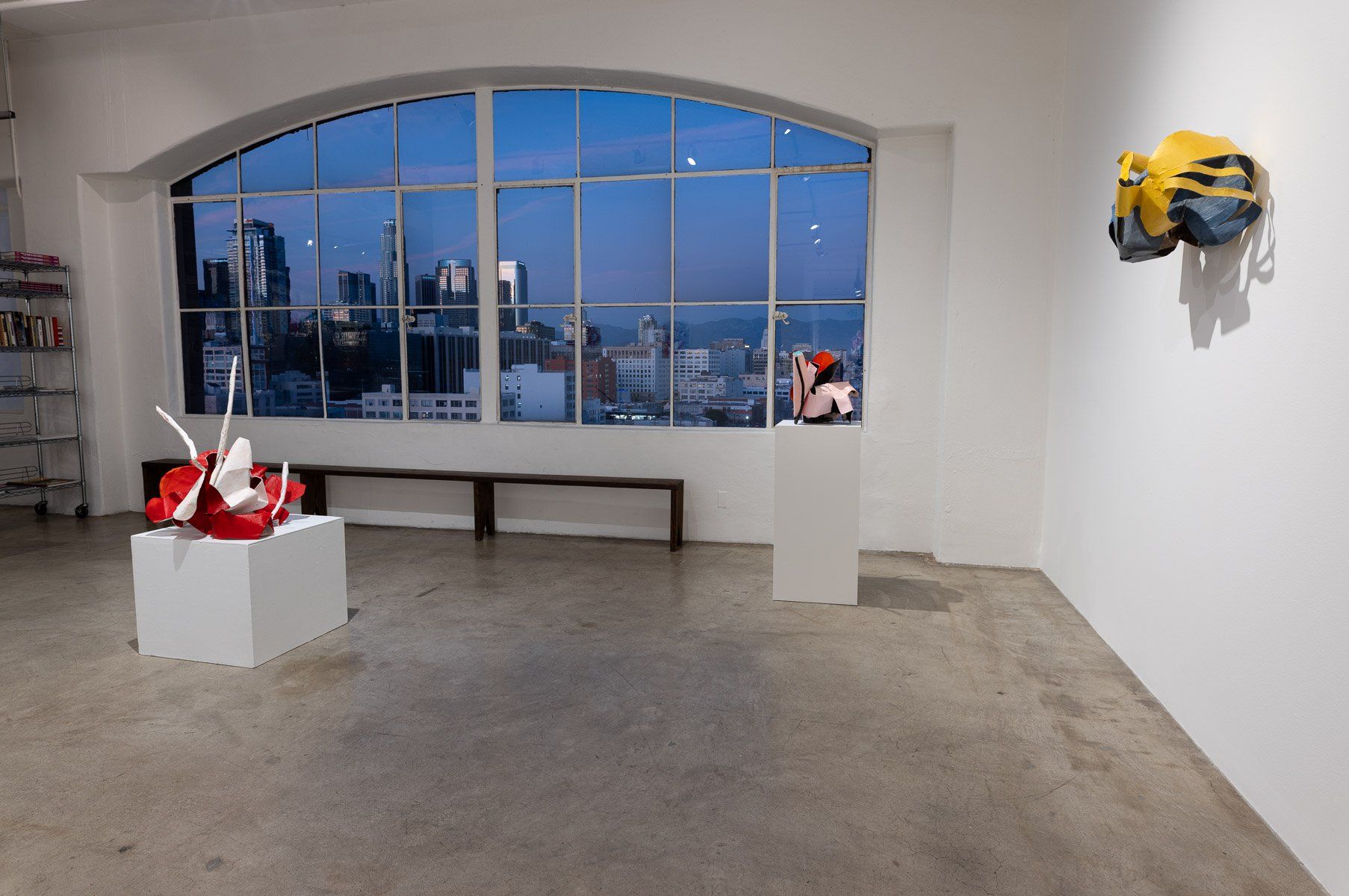 A room with a large window and a few sculptures on display