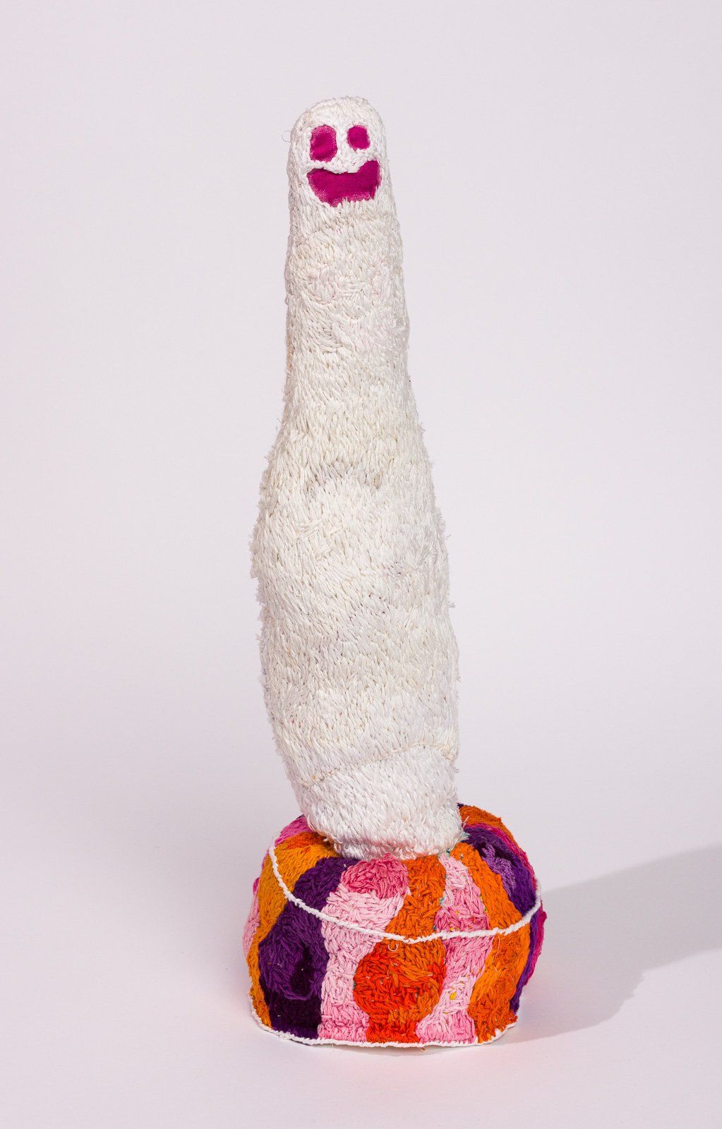 A sculpture of a bottle with a smiley face on it.