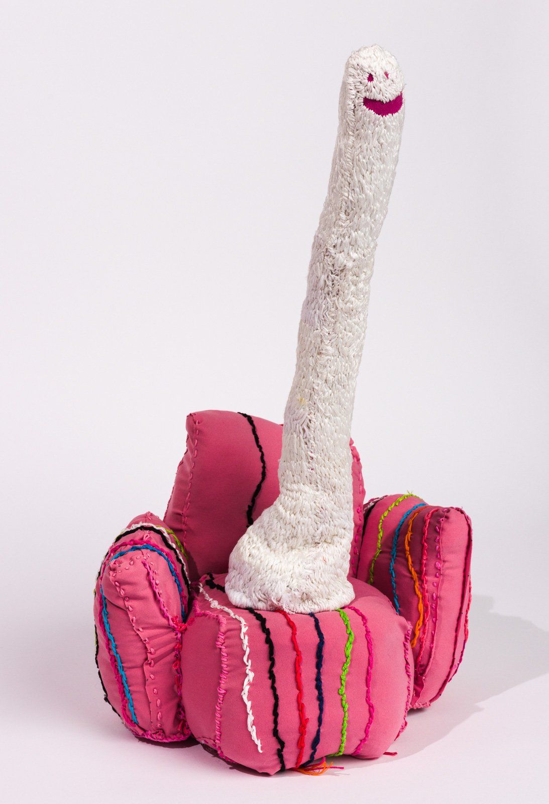 A stuffed animal with a long neck is sitting on a pink chair.