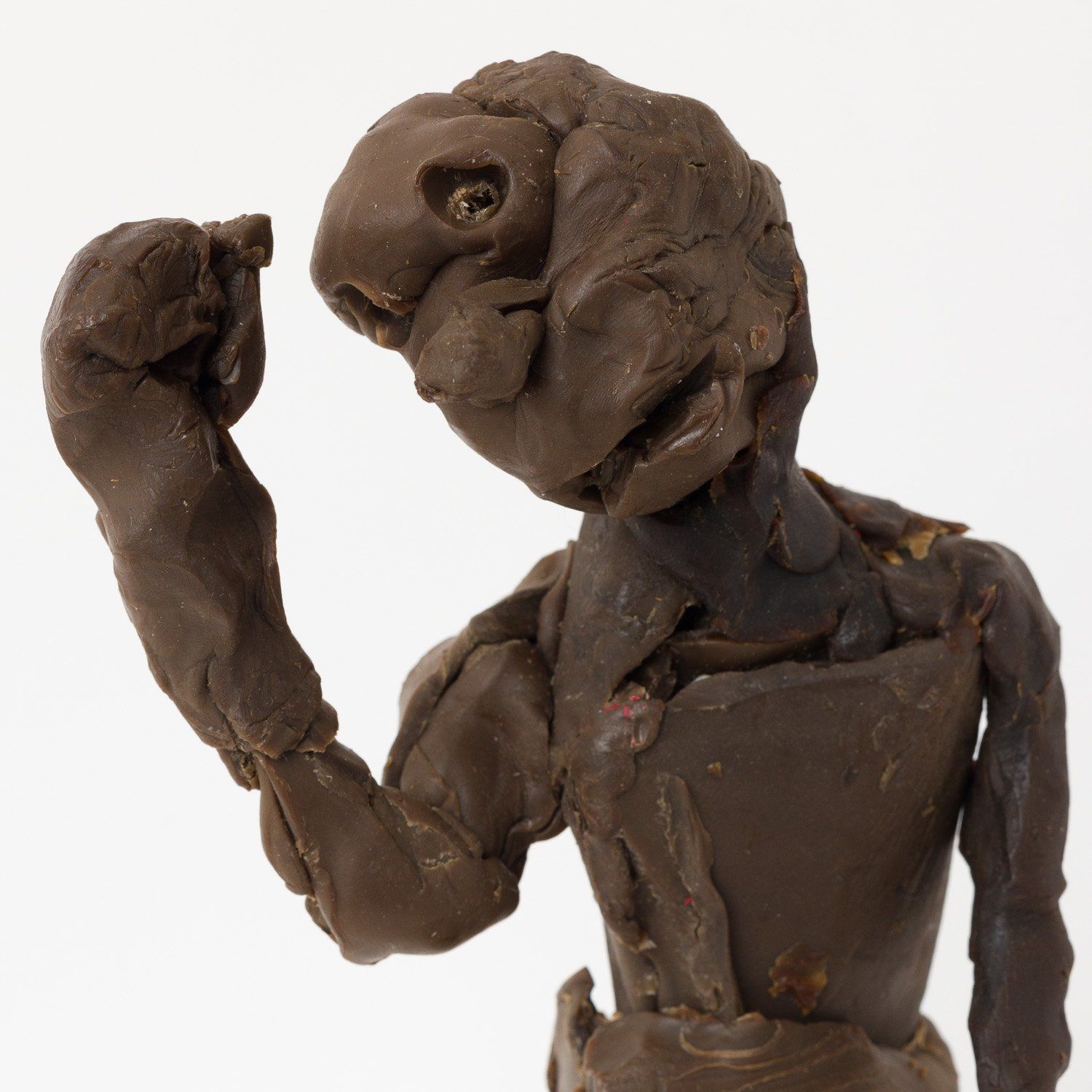 A clay sculpture of a man flexing his arm