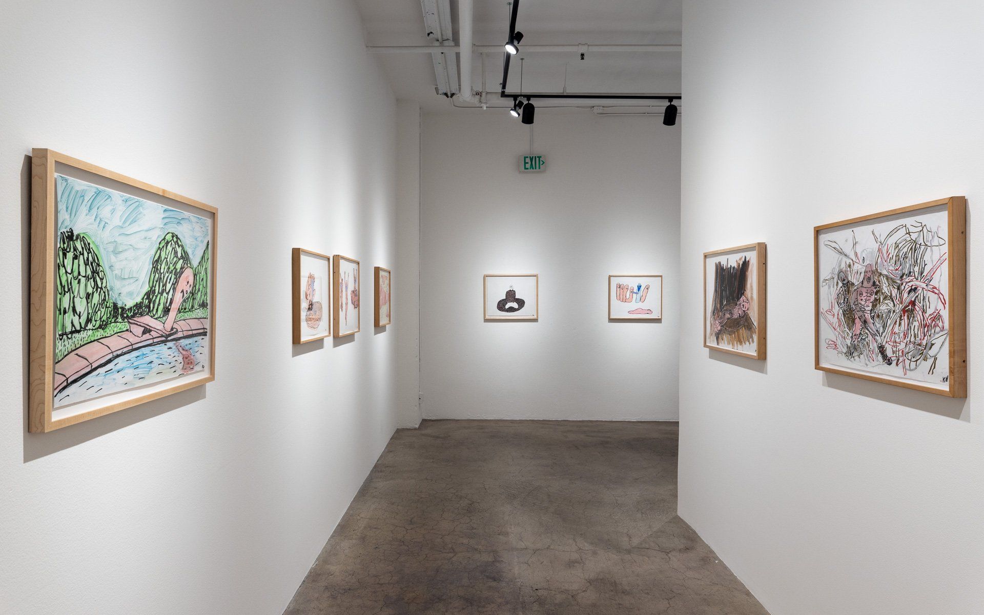 A hallway with paintings on the wall in Track 16 Gallery.