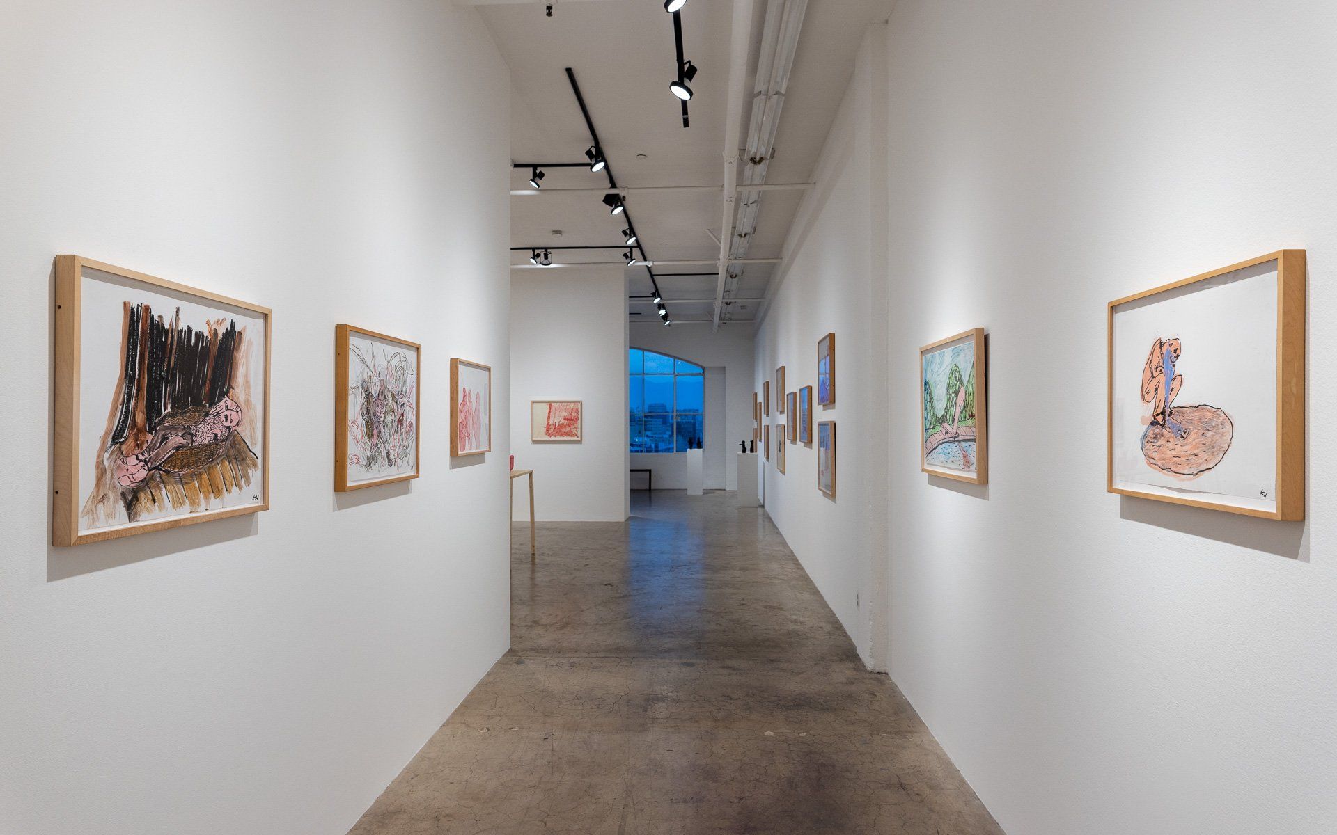 A long hallway filled with paintings on the walls of a museum.
