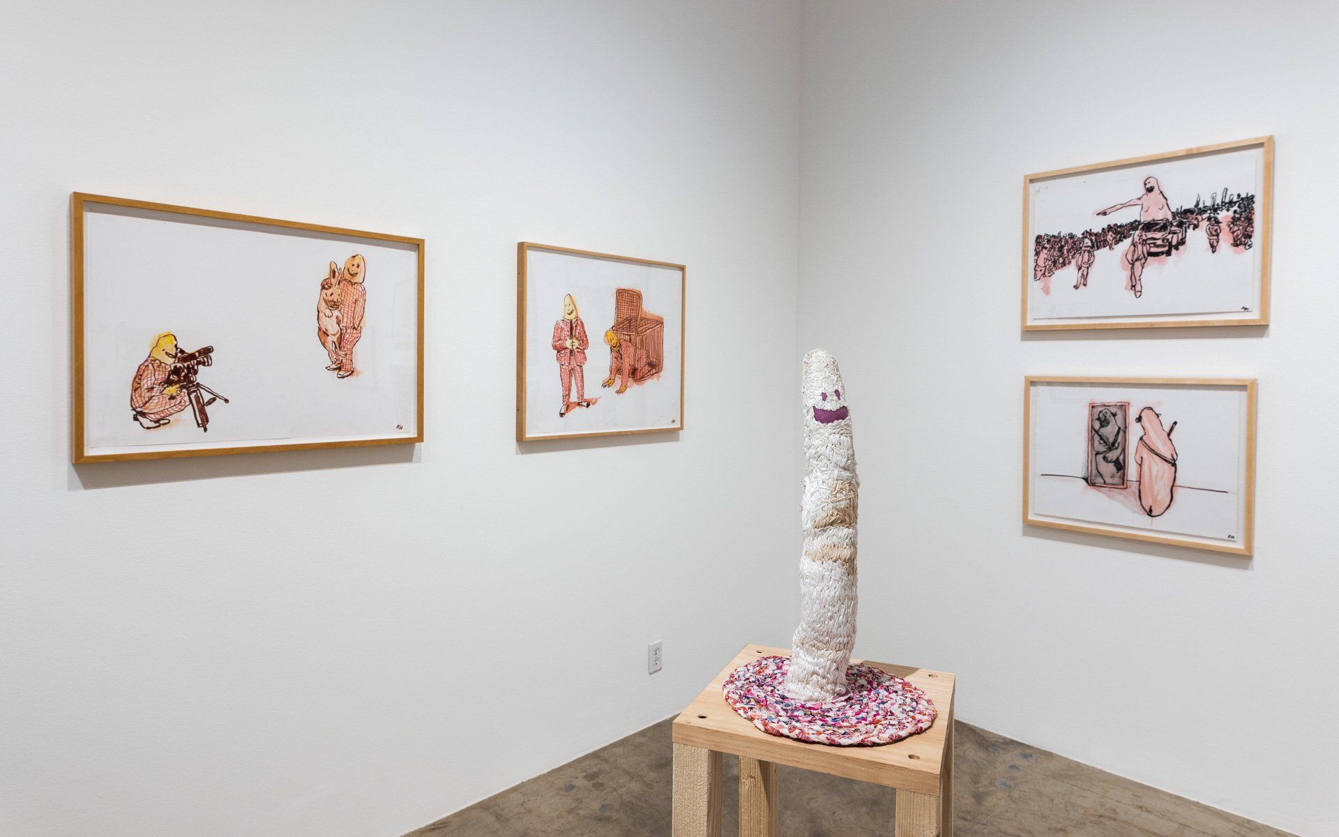 A room with a sculpture on a table and paintings on the wall.