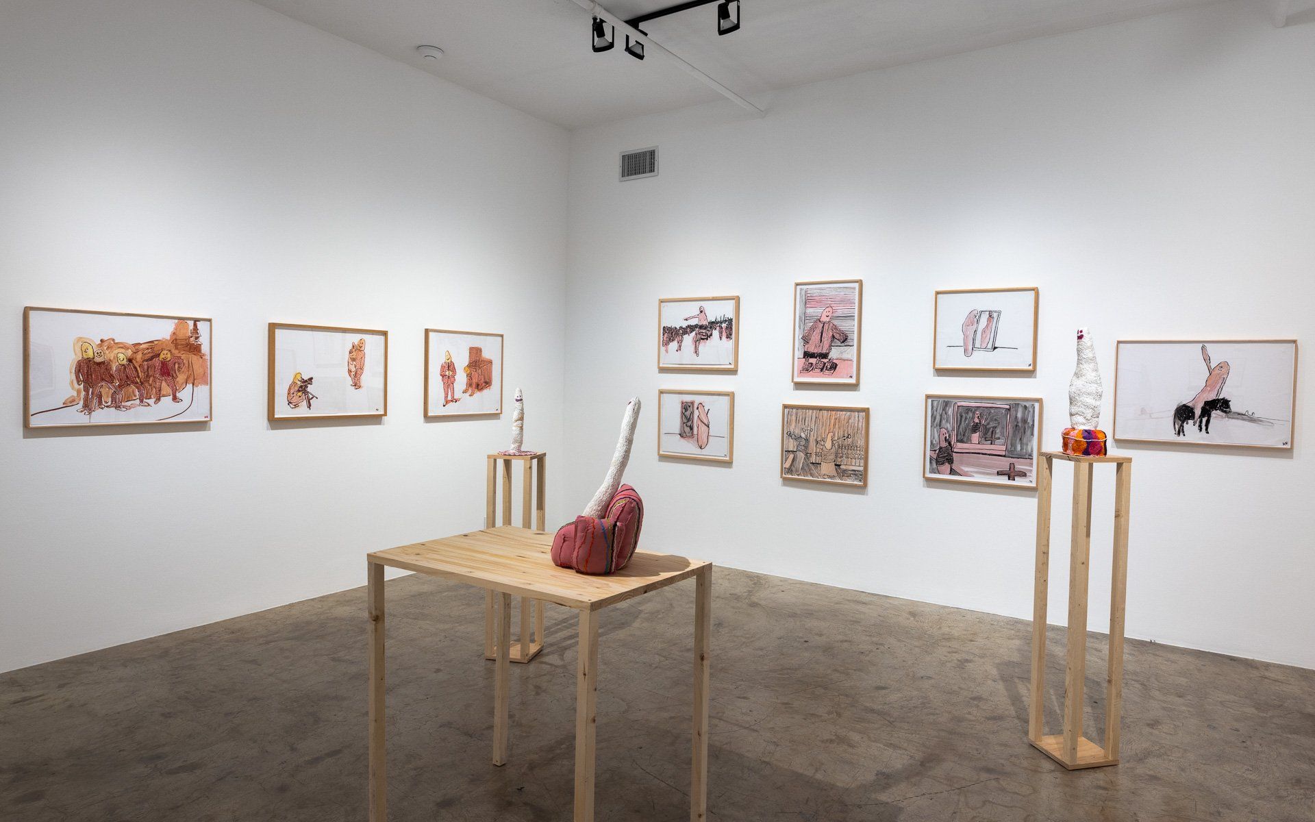 A room with a table and chairs and paintings on the wall.