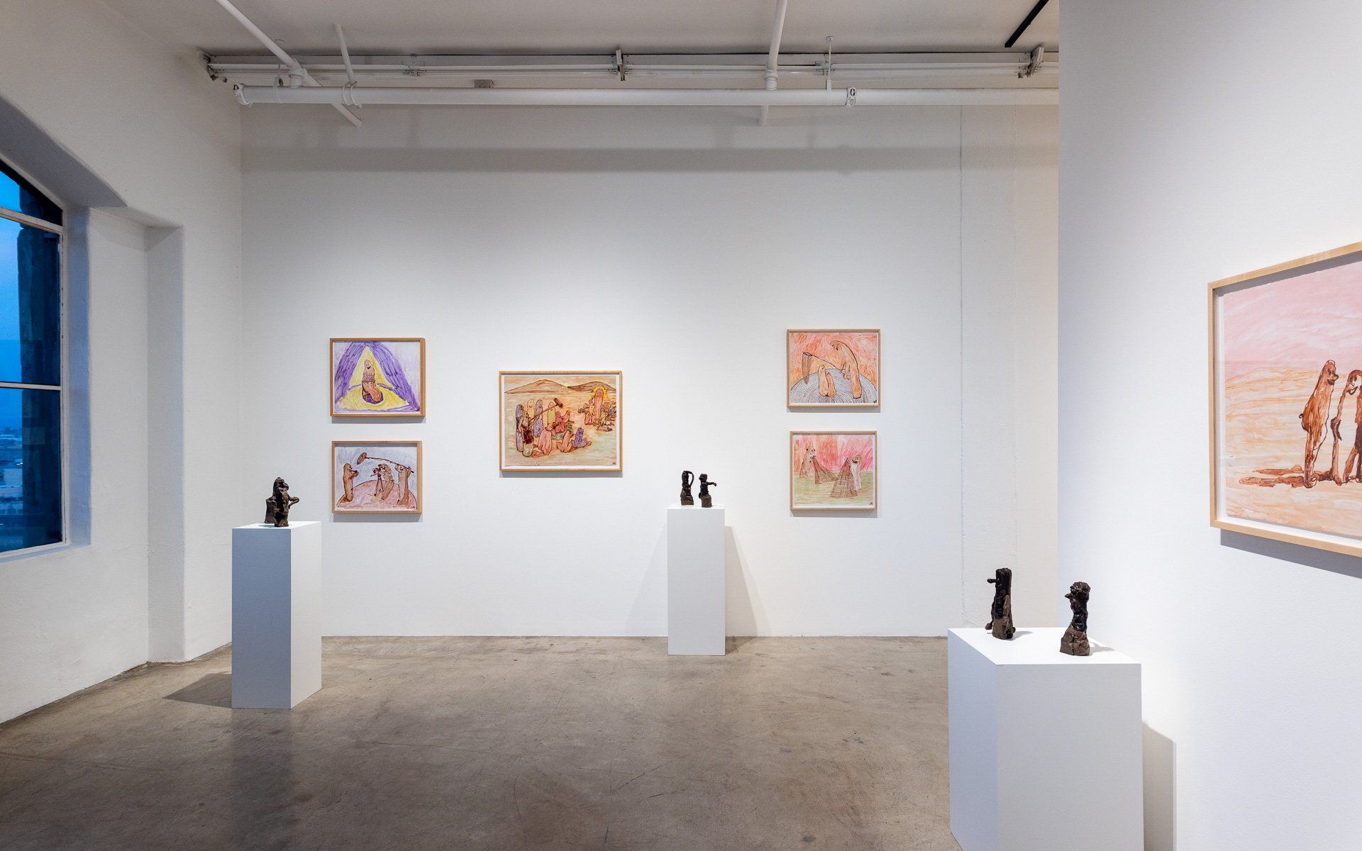A room with a lot of paintings and sculptures on display.
