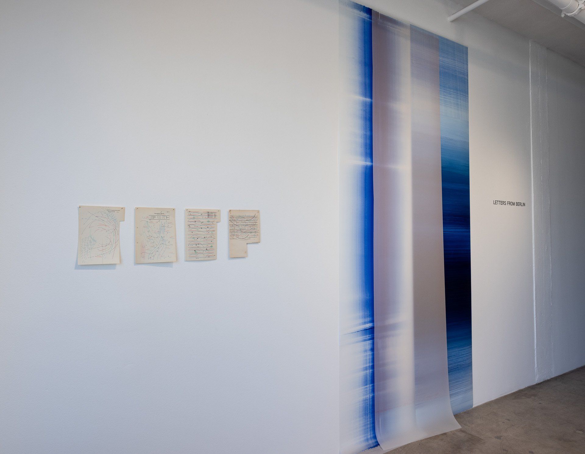 A white wall with blue and white paintings on it.