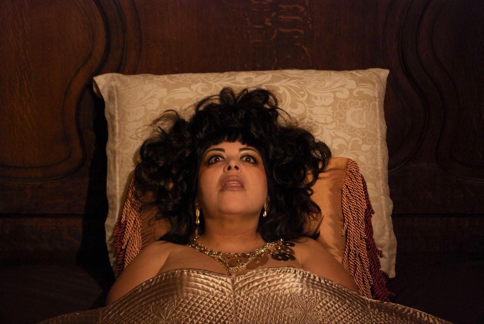 A woman is laying in bed with her head on a pillow.