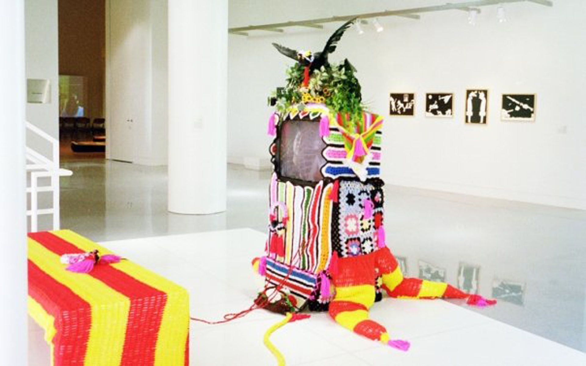 A colorful sculpture is sitting on the floor in a museum.