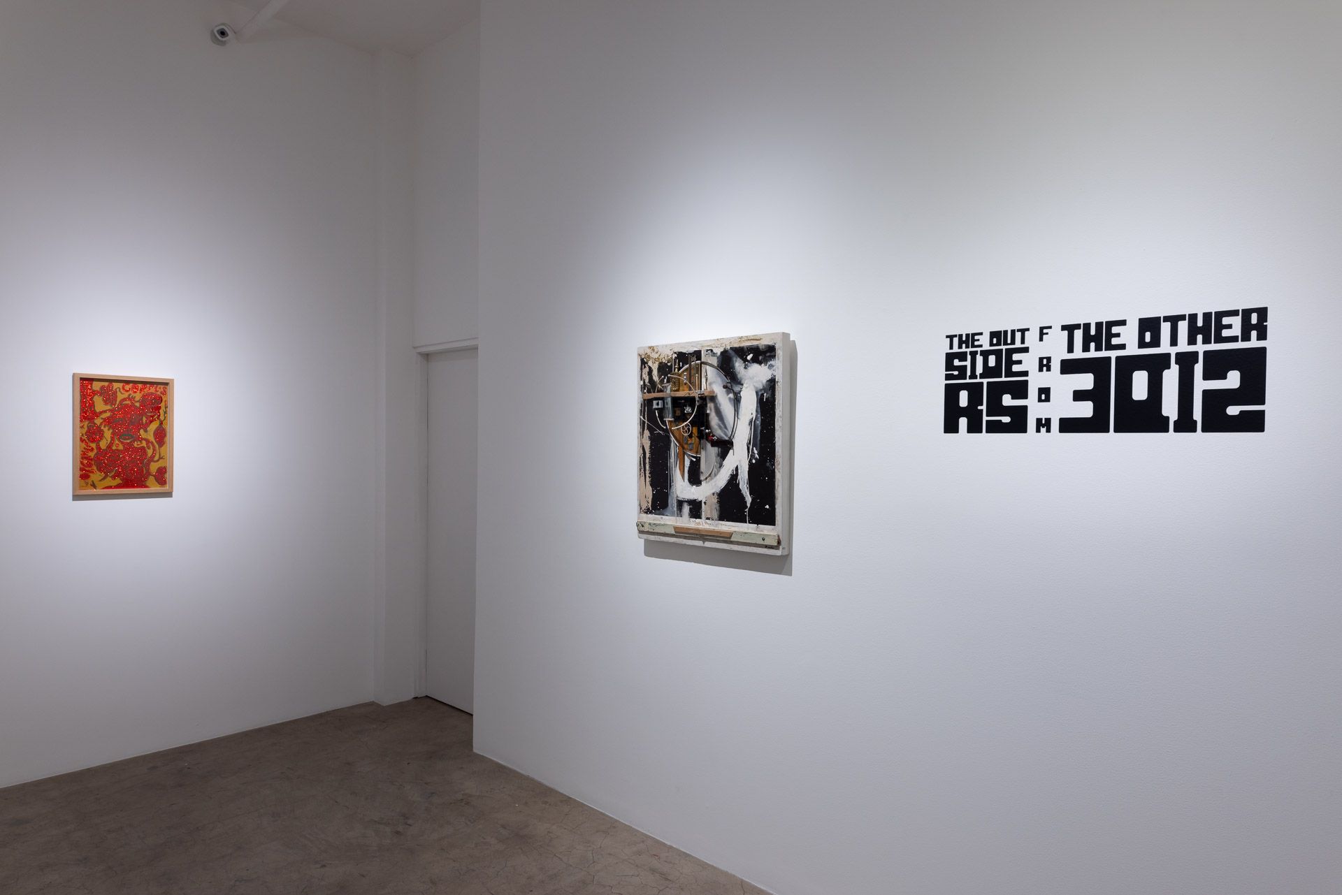 There are three paintings on the wall in a room.