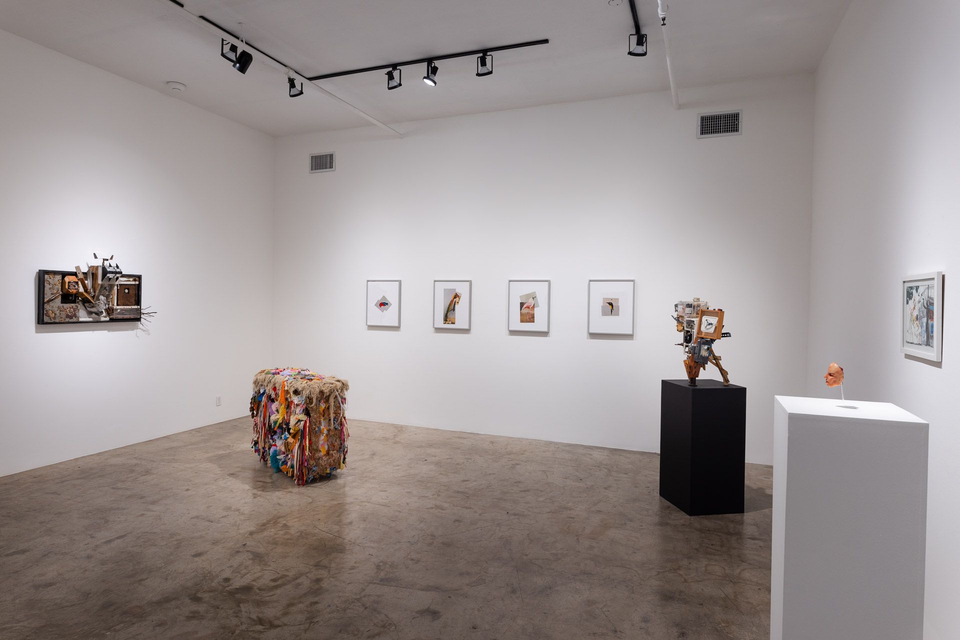 A room with a lot of paintings and sculptures on the walls.