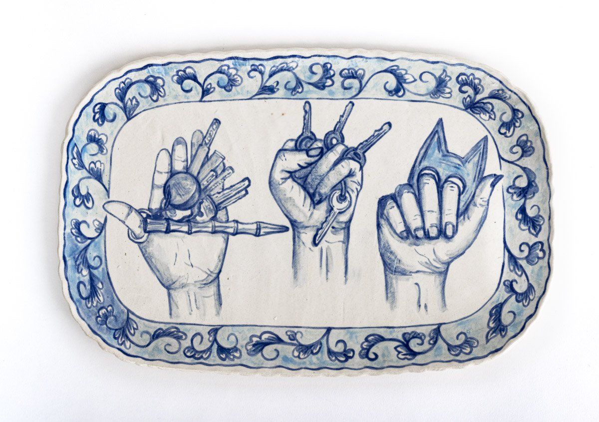 A blue and white plate with three hands on it