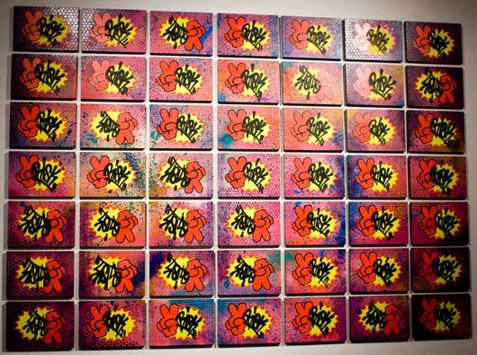 A bunch of cards are stacked on top of each other on a wall.