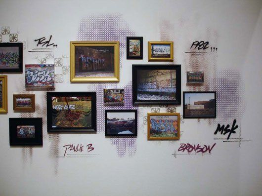 A wall with a bunch of framed pictures on it