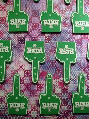 A bunch of green foam fingers with the word risk on them