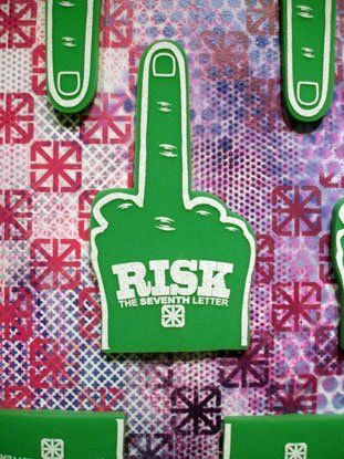 A green foam finger with the word risk on it