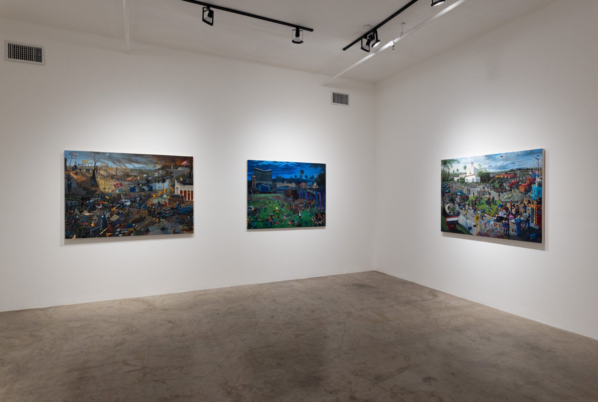 A room with three paintings hanging on the wall.