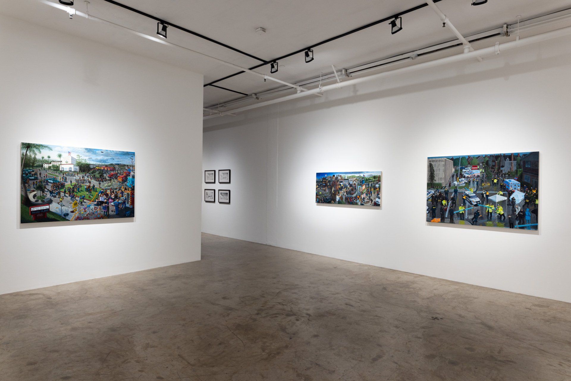 A large empty room with three paintings on the wall.