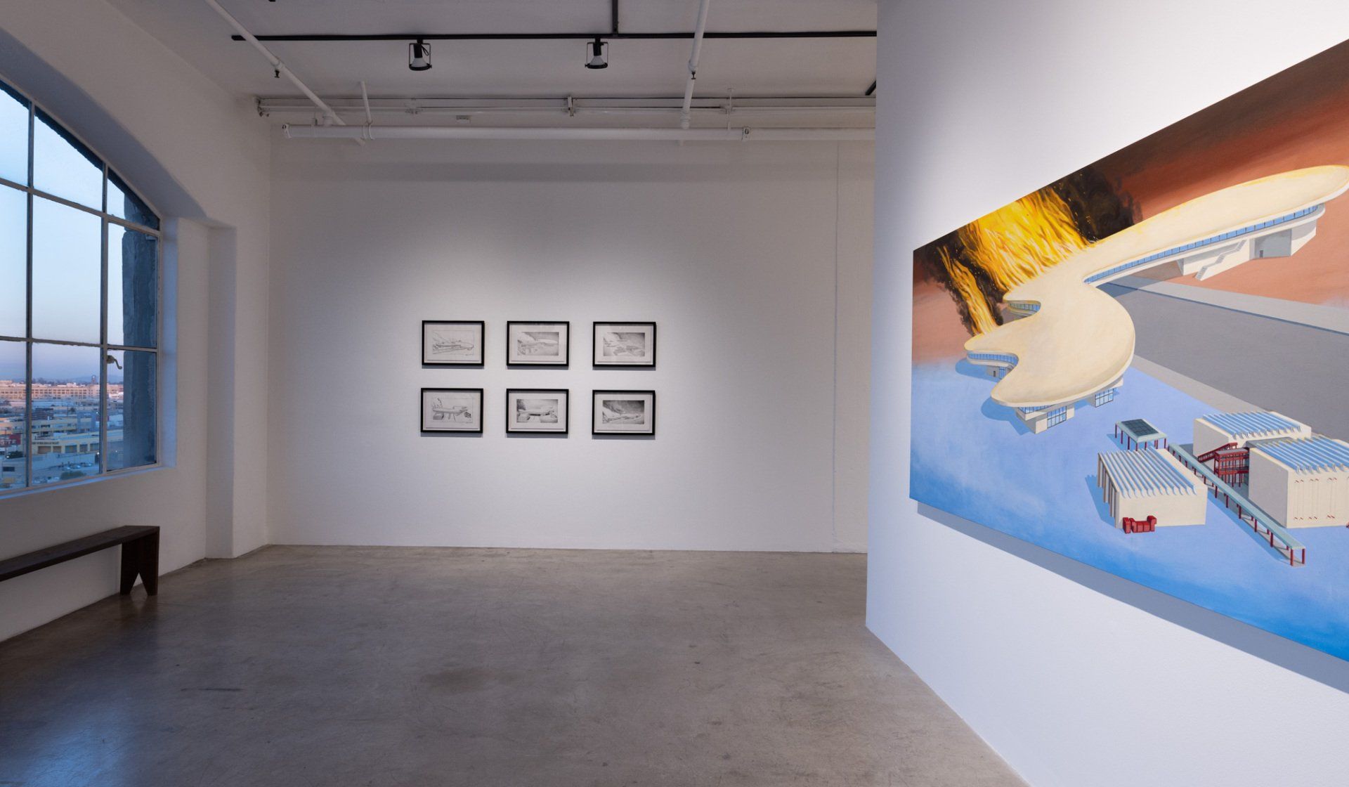 A large empty room with a painting on the wall.