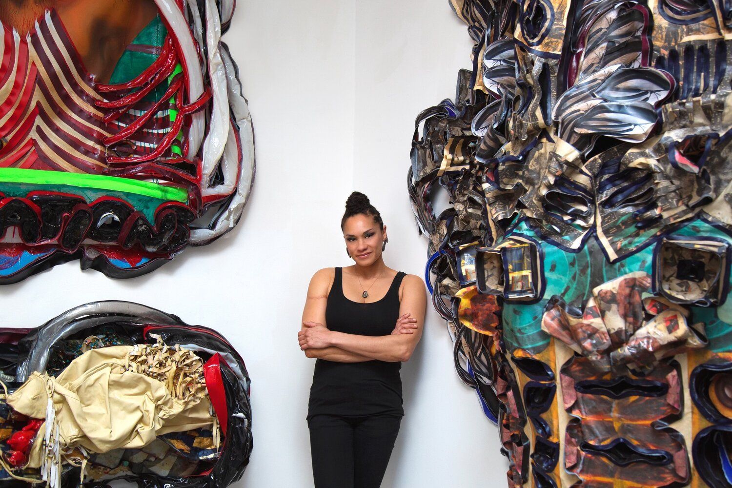 A woman is standing in front of a wall with paintings on it.