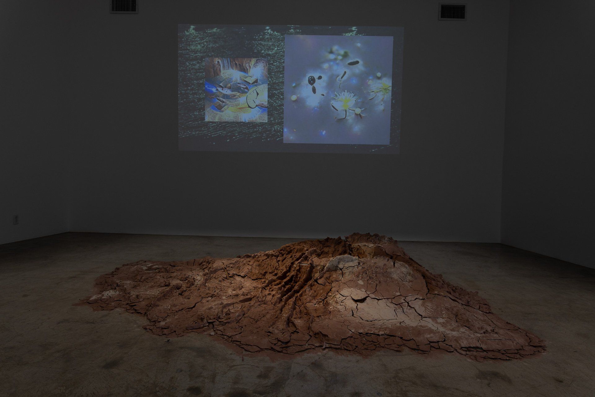 A large pile of dirt is sitting on the floor in a dark room.